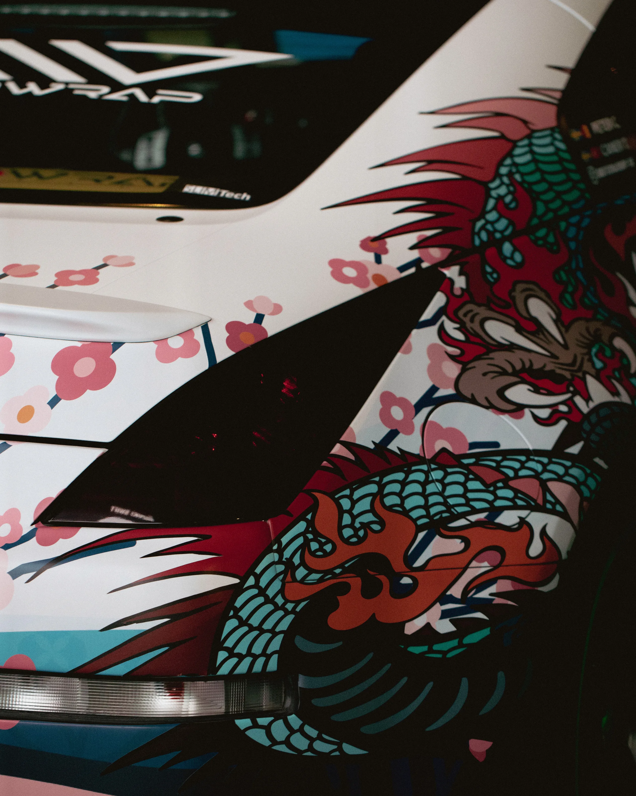 Close-up of a race car covered in a dragon and cherry blossom livery