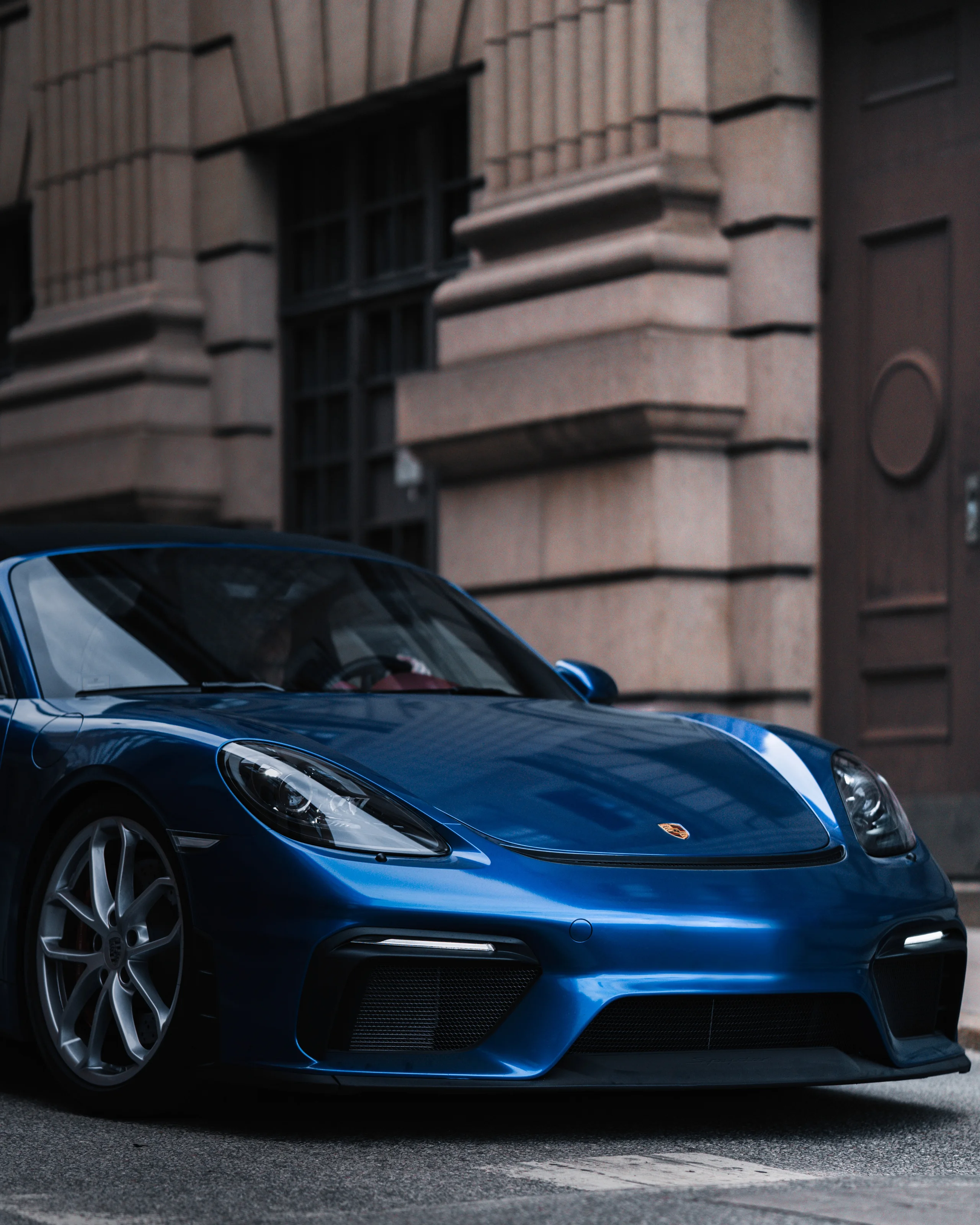 Blue sports car parked in front of a stone building
