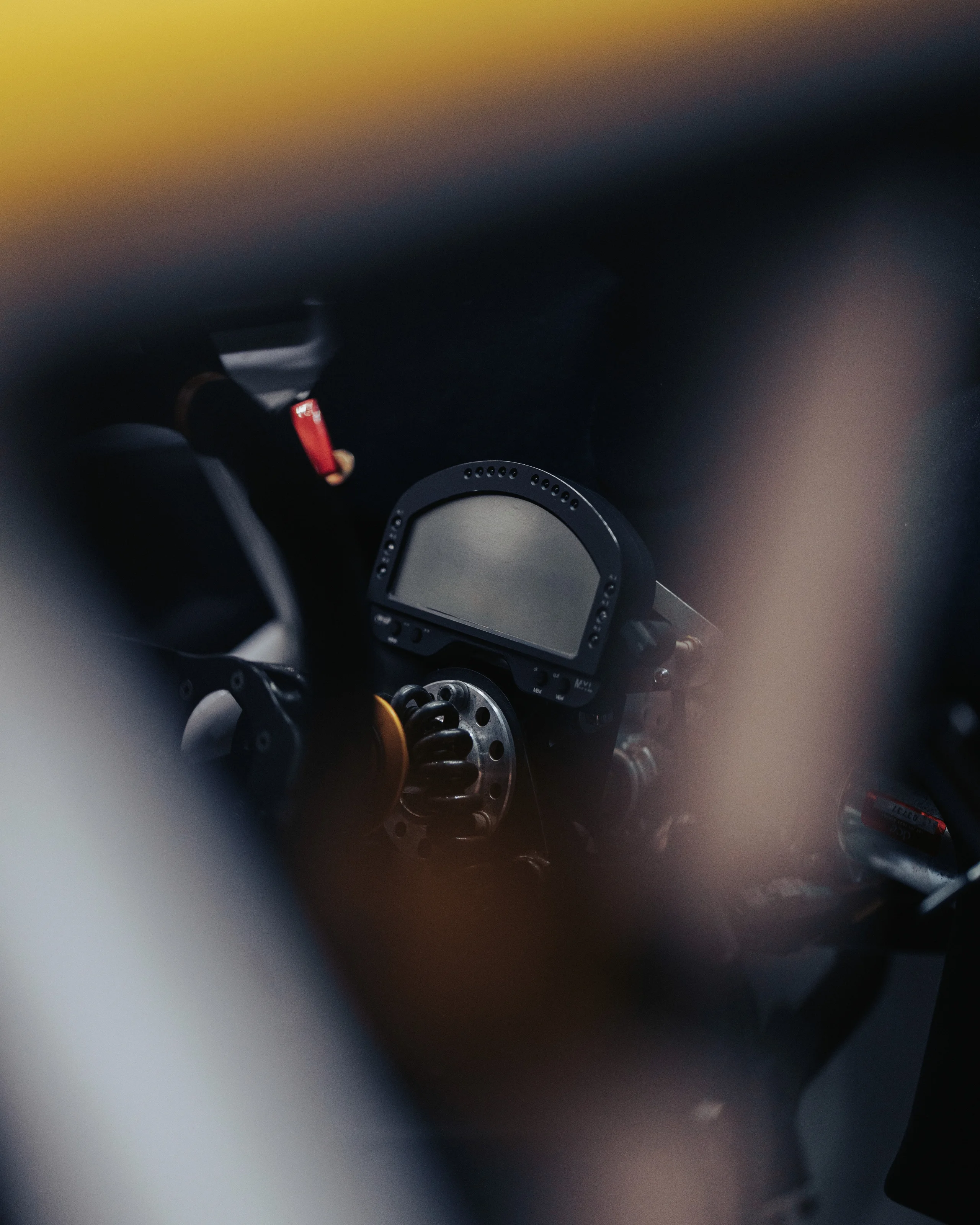Steering wheel and dashboard seen through the window of a race car